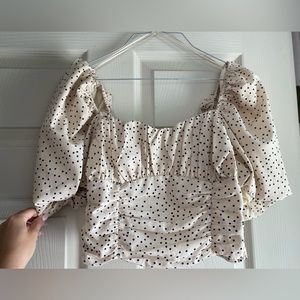 Cream poka dot crop top with puff sleeves.